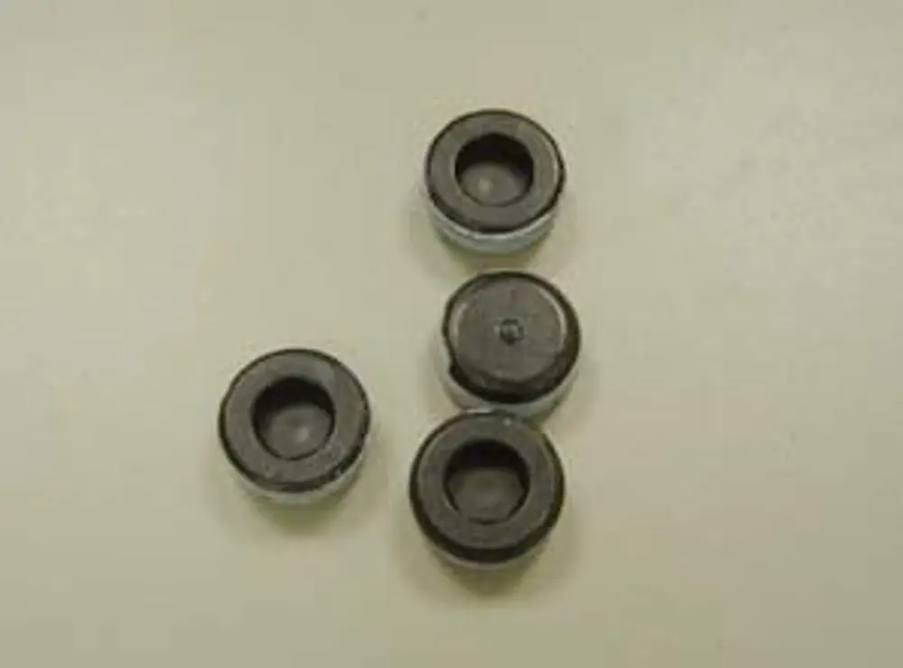 Vier schwarze Stopfen mit Metallrand auf hellem Untergrund, geeignet für Remeha Wärmetauscher.